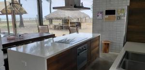 a kitchen with a counter and a table with chairs at Casa frente al Mar EL PARAISO, Cojimies in Pedernales