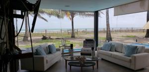 a living room with couches and a view of the beach at Casa frente al Mar EL PARAISO, Cojimies in Pedernales