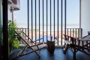 a balcony with two chairs and a large window at Lovely Guesthouse 94 in Hua Hin
