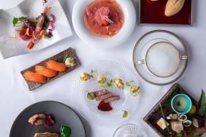 a table with plates of food and a cup of coffee at Matsumoto Hotel Kagetsu in Matsumoto