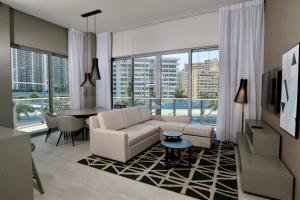 een woonkamer met een witte bank en een tafel bij Luxury Two Bed Two Bath Beach Resort Condo 35 USD resort fee per day in Hollywood