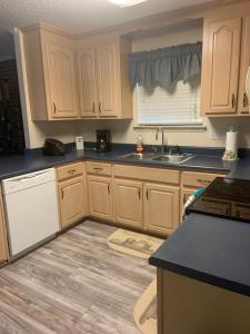 a kitchen with wooden cabinets and a sink at Cozy comfortable & convenient in Pensacola