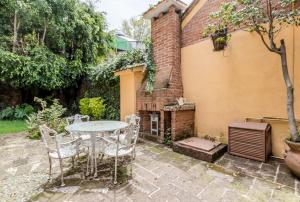 a patio with a table and chairs next to a building at Suites Cuija Coyoacan in Mexico City