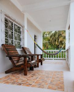 een veranda met 2 stoelen en een hangmat bij Wanigi Guesthouse in Punta Gorda
