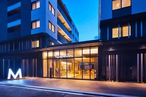 a building with a large glass window in front of it at Hotel Pagong with M's in Kyoto