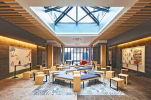 una habitación con un montón de mesas y bancos en Hotel Pagong with M's en Kioto
