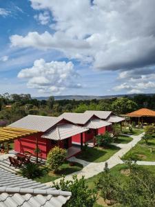 ein rotes Gebäude mit einem Dach darüber in der Unterkunft Vila da Mata Chalés in Alto Paraíso de Goiás