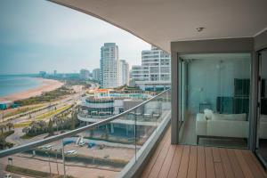 a balcony with a view of the beach and buildings at Alexander Beach Punta del Este in Punta del Este