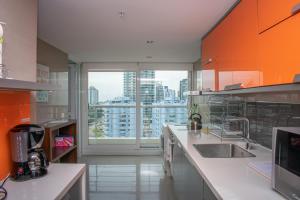 a kitchen with a sink and a large window at Alexander Beach Punta del Este in Punta del Este