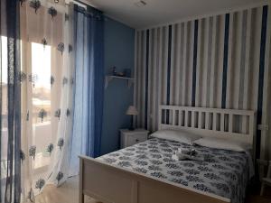 1 dormitorio con 1 cama con paredes y cortinas azules en B&B VelAmare, en Salerno