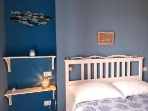 1 dormitorio con cama y pared azul en B&B VelAmare, en Salerno