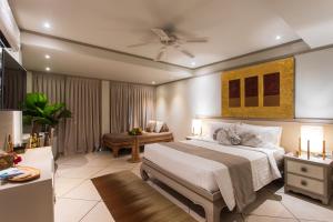a bedroom with a large bed with a ceiling fan at Rocky's Boutique Resort - Veranda Collection Samui in Lamai