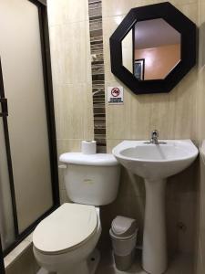 a bathroom with a toilet and a sink and a mirror at Hostal Bellagio in Guayaquil