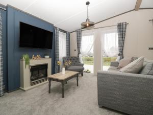 a living room with a couch and a tv at 14 Fairways in Burnham on Sea