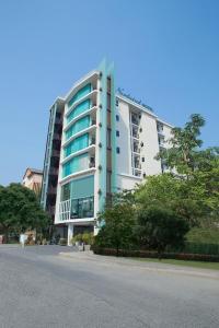 a large white building with balconies on a street at Nordwind Hotel in Chiang Mai