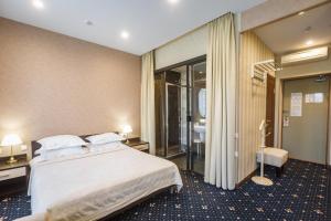 Habitación de hotel con cama y baño en Sapporo Hotel, en Khabarovsk