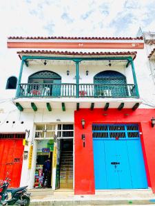 un edificio con puertas azules y rojas y balcón en Hostal La Española de Getsemani, en Cartagena de Indias