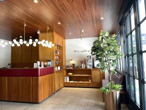 a restaurant lobby with a counter and a plant at River inn Station in Kaohsiung