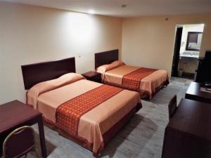 a hotel room with two beds in a room at Texas Inn Harlingen in Harlingen