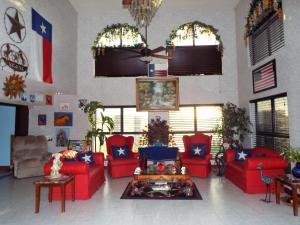 a living room with red couches and a table at Texas Inn Harlingen in Harlingen +9 photos