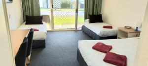 a hotel room with two beds and a balcony at Barmera Lake Resort Motel in Barmera