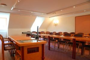 una sala de conferencias con mesas y sillas de madera en Schreiner's - Das Waldviertel Haus en Laimbach am Ostrong