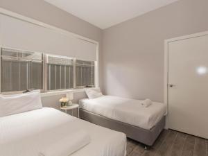1 dormitorio con 2 camas y ventana en 43A Twynam Street, en Jindabyne