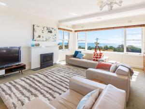 a living room with a fireplace and a tv at Beach Belle Mornington in Mornington