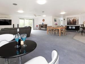 a living room with a couch and a table with wine glasses at Dromana Bay Views Dromana in Dromana