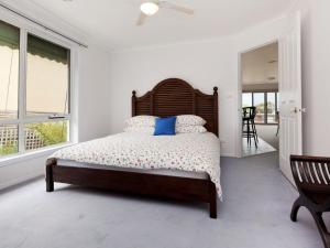 a bedroom with a large bed with a wooden headboard at Dromana Bay Views Dromana in Dromana