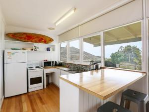 a kitchen with white appliances and a pizza on the ceiling at DROMANA BEACH SHACK in Dromana