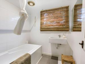 a white bathroom with a tub and a sink at LANAI HOUSE BALNARRING BEACH in Balnarring Beach