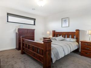 a bedroom with a wooden bed and a dresser at La Dolce Vita Retreat Rye in Rye