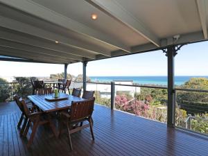 a deck with a table and chairs and the ocean at Bay Views On Browne in Dromana