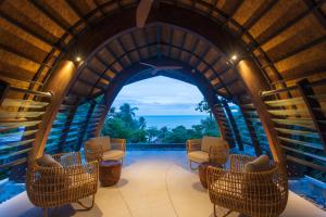 an arched room with chairs and a view of the ocean at Rocky's Boutique Resort - Veranda Collection Samui in Lamai