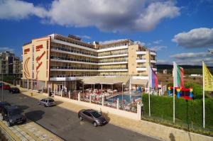 a large building with a pool in a parking lot at Hotel Plamena Palace in Primorsko