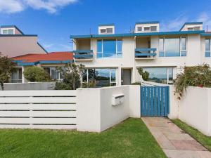 a house with a blue gate and a white fence at Seaviews Mornington in Mornington
