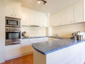a kitchen with white cabinets and a granite counter top at Seaviews Mornington in Mornington