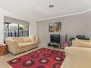 a living room with a couch and a television at Sweetlands Sanctuary in Mount Martha