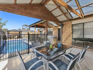 a patio with a table and chairs and a swimming pool at Sweetlands Sanctuary in Mount Martha