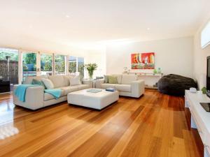 een woonkamer met witte meubels en houten vloeren bij WAIKIKI BLAIRGOWRIE in Blairgowrie