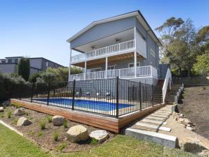 a house with a swimming pool behind a fence at Windspray Mount Martha in Mount Martha