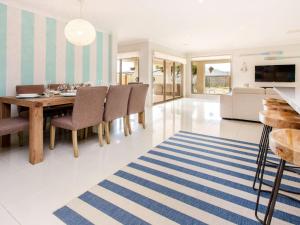 a dining room and living room with a table and chairs at Malibu Safety Beach in Safety Beach