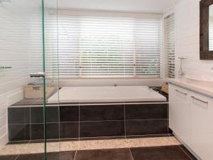 a bathroom with a tub and a glass shower at Moonah Sands Rye in Rye