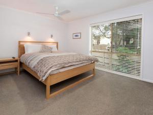 a bedroom with a bed and a large window at Moonah Sands Rye in Rye