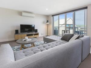 a living room with a couch and a tv and a table at Ocean Beach Retreat Sorrento in Sorrento