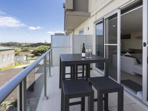 a balcony with a black table and two stools at Ocean Beach Retreat Sorrento in Sorrento