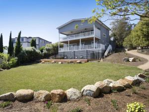 a house with a yard with rocks in front of it at Windspray Mount Martha in Mount Martha