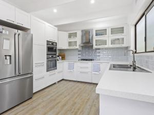 a kitchen with white cabinets and a stainless steel refrigerator at BAYSHORE - DROMANA in Dromana