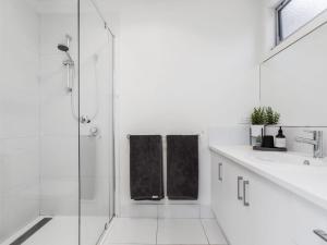 a white bathroom with a shower and a sink at You Me And The Sea Blairgowrie in Blairgowrie +13 photos